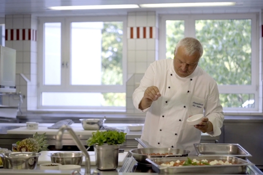 Ein Koch würzt das Essen Ein Koch würzt das Essen